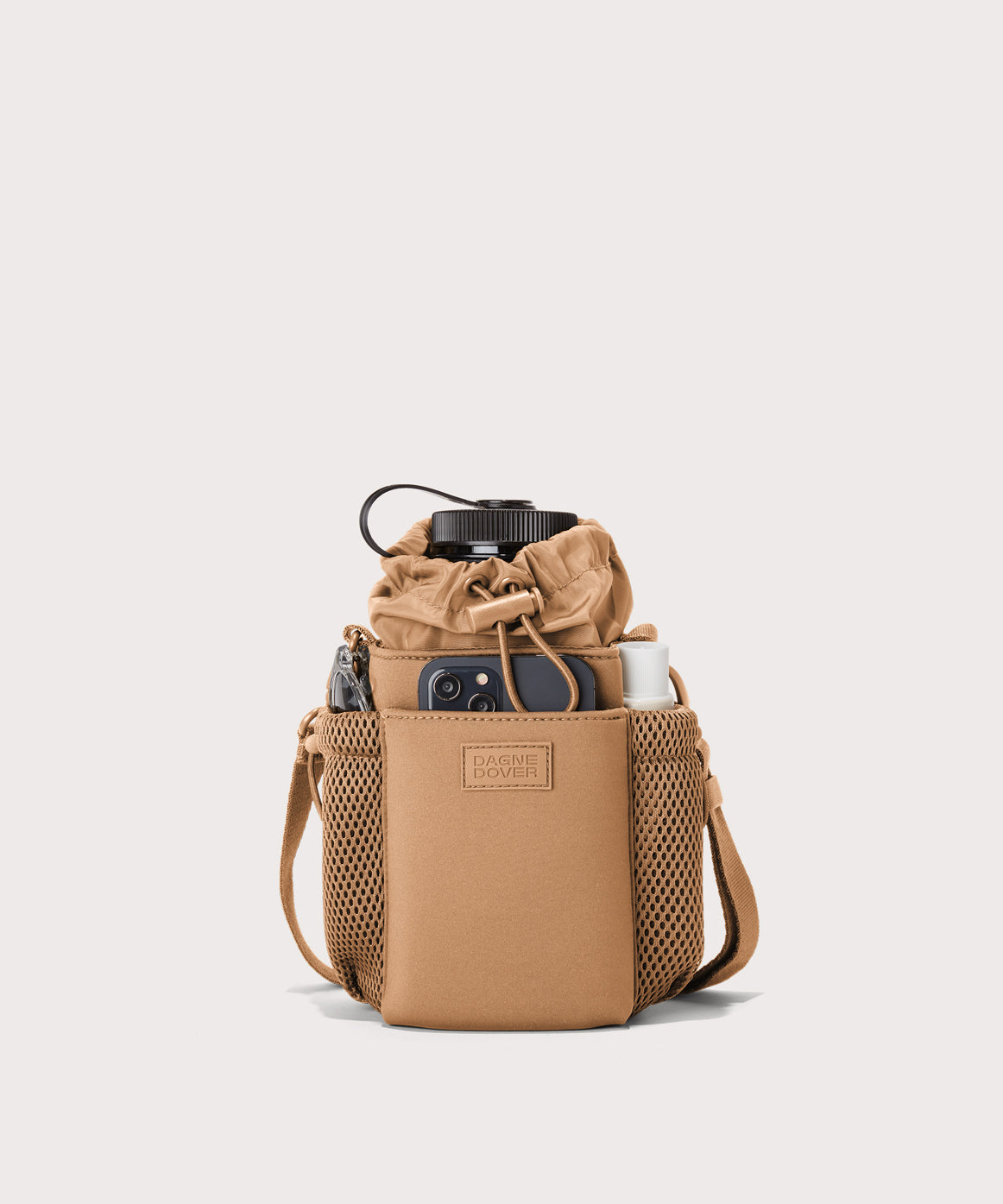Dagne Dover Sloan Water Bottle Sling in camel brown containing a water bottle and accessories.
